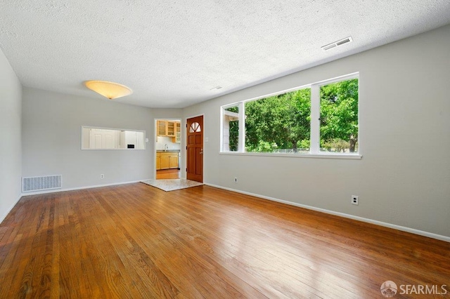 1835 Clayton Way, Concord, CA 94519 - unfurnished living room featuring wood finished floors, a textured ceiling, baseboards, and a sink