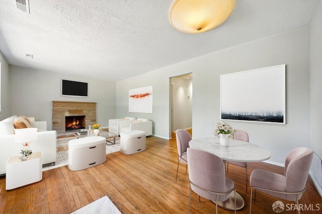 1835 Clayton Way, Concord, CA 94519 - living room featuring wood finished floors, a textured ceiling, a lit fireplace, and baseboards