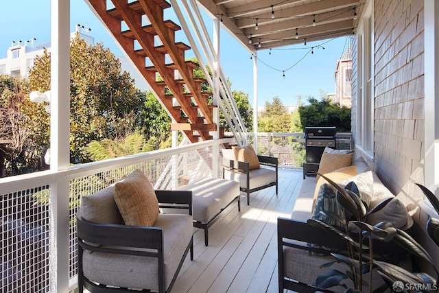 wooden deck with area for grilling and an outdoor hangout area