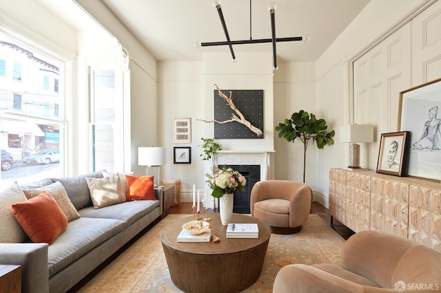 living area featuring a wealth of natural light, baseboards, and a fireplace