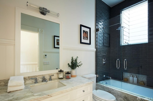 full bathroom featuring tiled shower / bath, plenty of natural light, vanity, and toilet