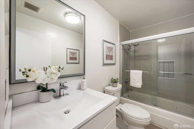 full bathroom with vanity, toilet, and combined bath / shower with glass door