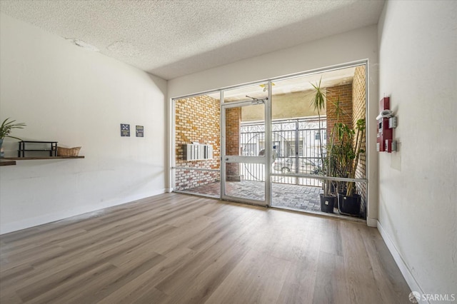 unfurnished room featuring hardwood / wood-style flooring and a textured ceiling