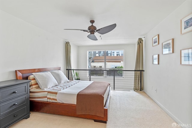 bedroom featuring light colored carpet, a ceiling fan, and baseboards