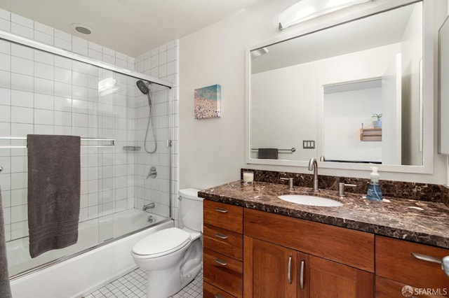 bathroom with tile patterned floors, vanity, toilet, and bath / shower combo with glass door