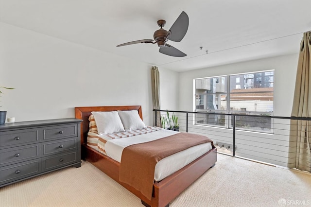bedroom featuring light colored carpet and a ceiling fan