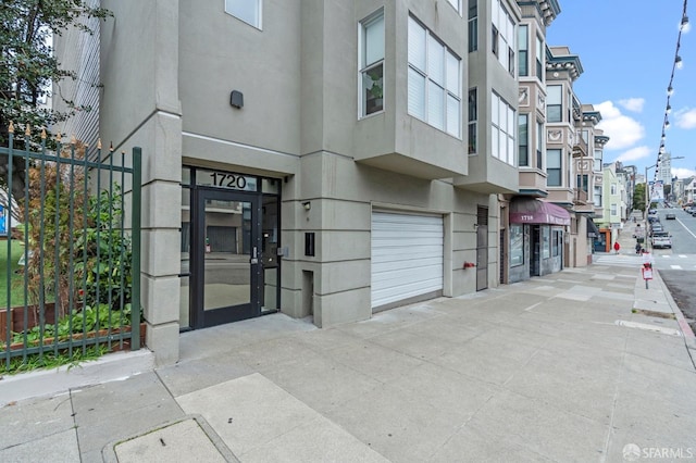 property entrance with stucco siding and an attached garage