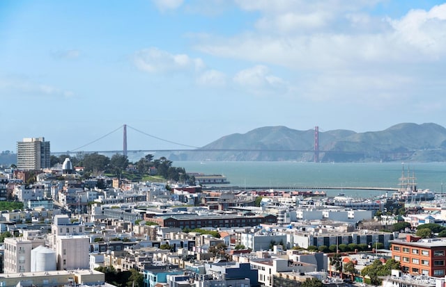 property's view of city with a water and mountain view