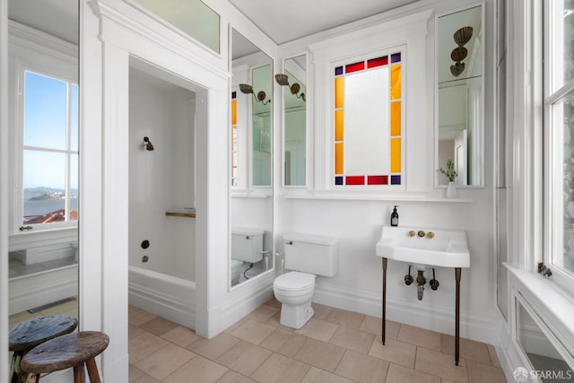 bathroom featuring a shower, tile patterned flooring, baseboards, and toilet