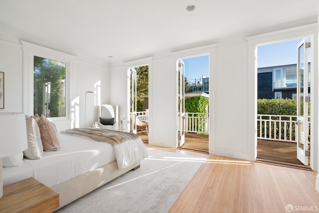 bedroom featuring access to exterior and wood finished floors