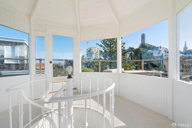 sunroom with lofted ceiling with beams and a view of city