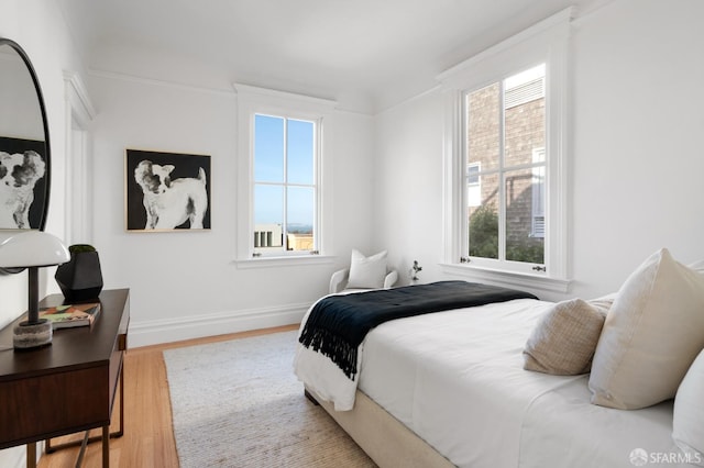 bedroom with baseboards and wood finished floors