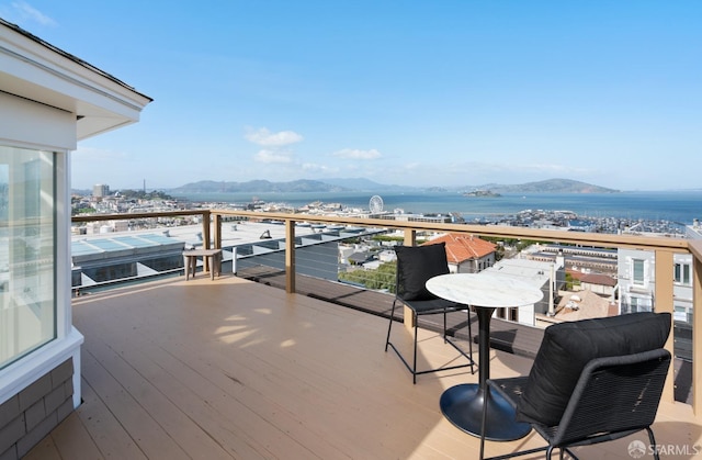 deck with a water and mountain view and a city view