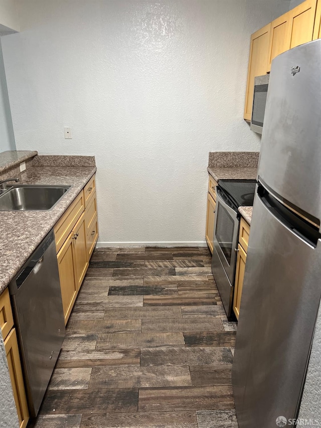 kitchen with appliances with stainless steel finishes, light brown cabinets, and sink