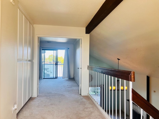 hallway featuring lofted ceiling with beams and light colored carpet