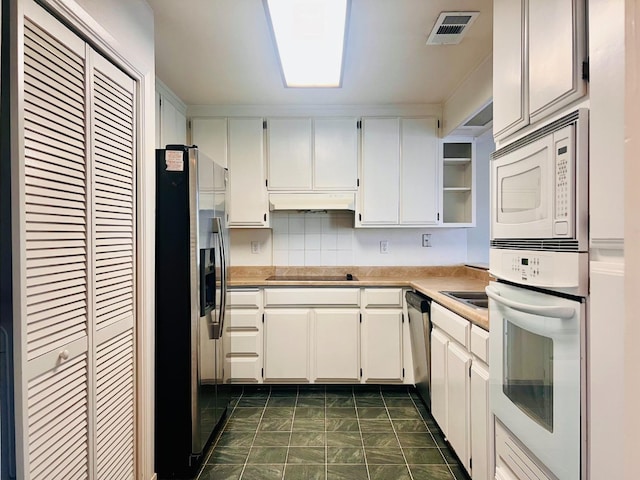 kitchen featuring decorative backsplash, white cabinetry, and stainless steel appliances