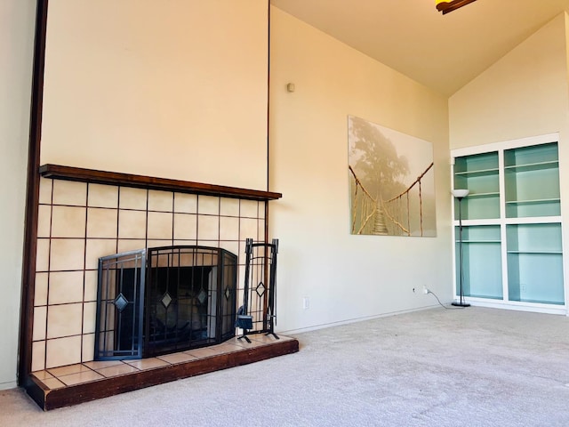 unfurnished living room featuring high vaulted ceiling, carpet flooring, and a tile fireplace