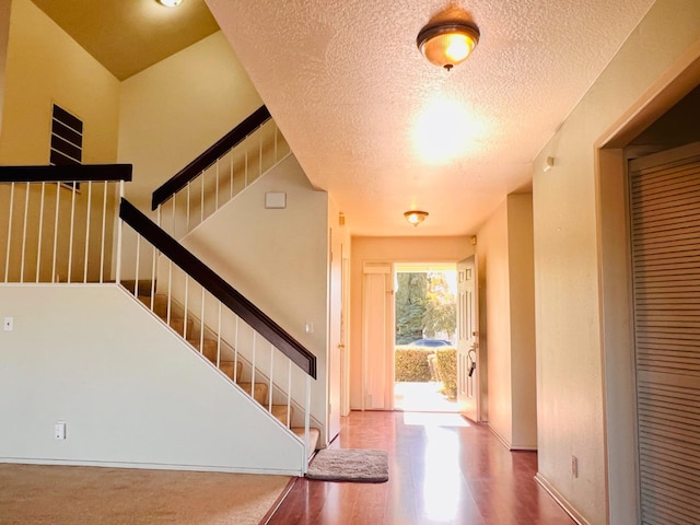 entrance foyer with a textured ceiling and hardwood / wood-style flooring