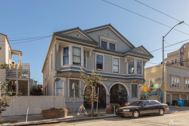 victorian house featuring fence