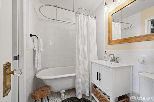 bathroom with tile walls, tile patterned floors, vanity, and shower / tub combo with curtain