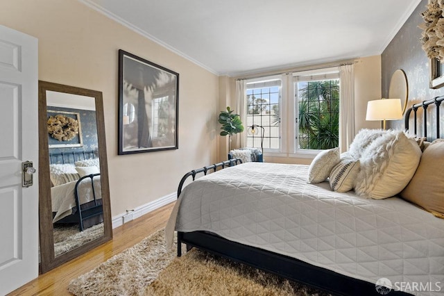 bedroom with crown molding and hardwood / wood-style floors