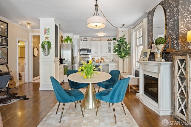 dining area featuring light hardwood / wood-style flooring and ornamental molding