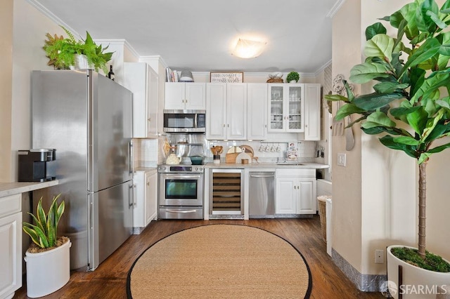 kitchen featuring stainless steel appliances, beverage cooler, white cabinetry, and sink