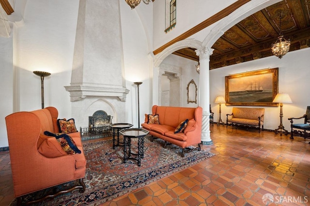 tiled living room featuring decorative columns and a large fireplace