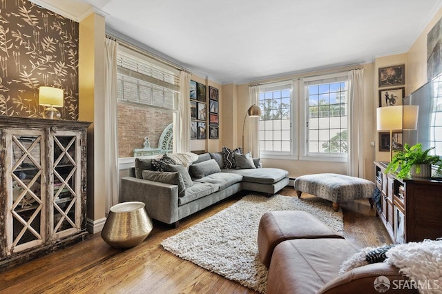 sitting room with wood-type flooring, a baseboard heating unit, and crown molding