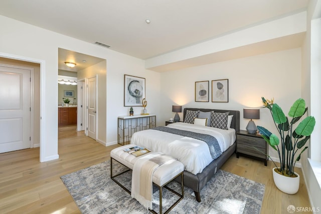 bedroom featuring light wood-style floors, visible vents, and baseboards