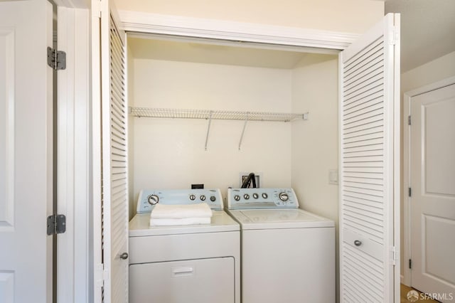 clothes washing area with washing machine and dryer and laundry area