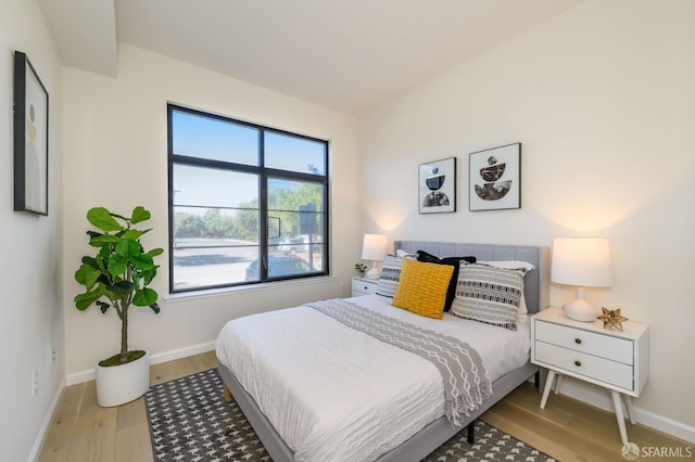 bedroom with baseboards and light wood finished floors