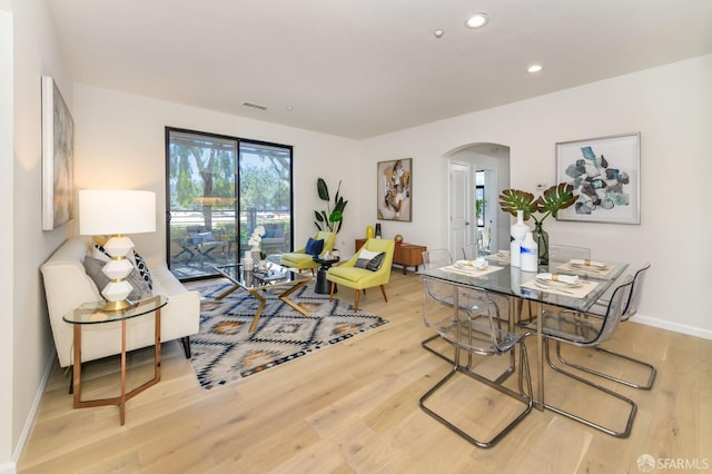 dining space with recessed lighting, visible vents, arched walkways, and light wood-style flooring