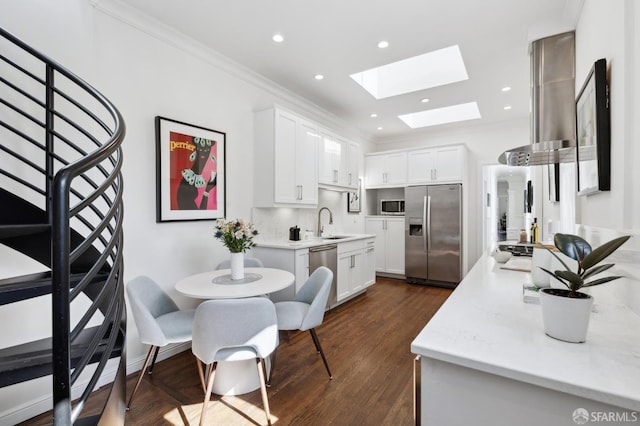 1370 Green St, San Francisco, CA 94109 - kitchen with appliances with stainless steel finishes, a skylight, ventilation hood, a sink, and white cabinetry