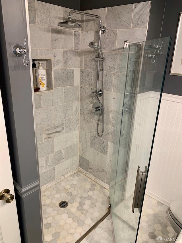 bathroom featuring toilet and a shower with shower door