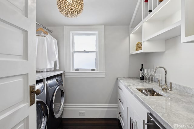 laundry room with washing machine and clothes dryer and wet bar