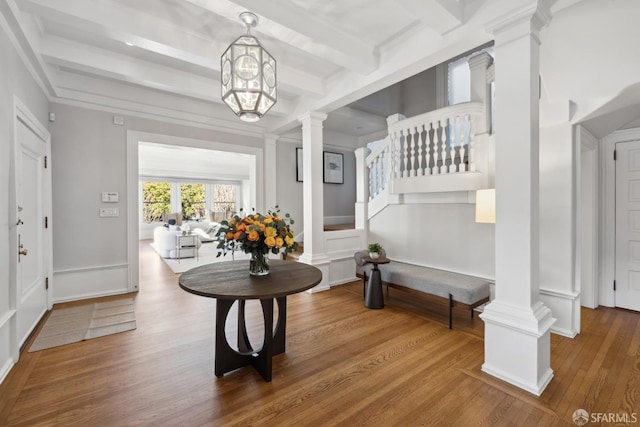 entryway featuring decorative columns, beam ceiling, crown molding, and wood-type flooring