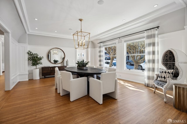 dining room featuring an inviting chandelier, hardwood / wood-style flooring, and ornamental molding