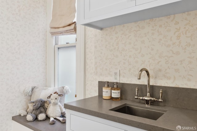 kitchen featuring white cabinets and sink