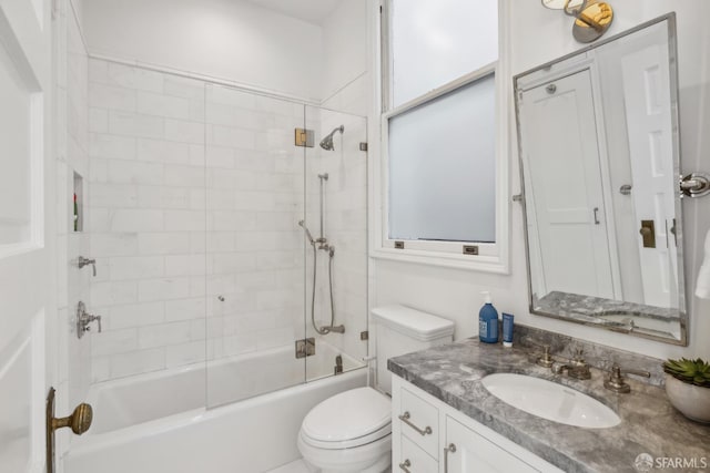 full bathroom featuring tiled shower / bath combo, toilet, and vanity