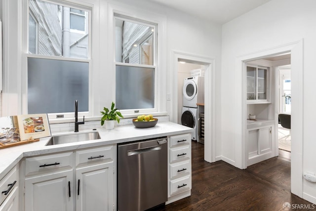 washroom featuring sink, stacked washing maching and dryer, and dark hardwood / wood-style floors