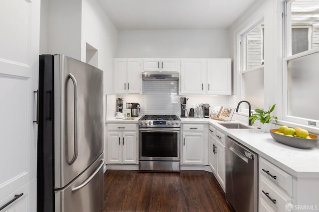 kitchen featuring white cabinets, appliances with stainless steel finishes, tasteful backsplash, and sink