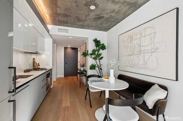 kitchen with light hardwood / wood-style flooring, white cabinets, and appliances with stainless steel finishes