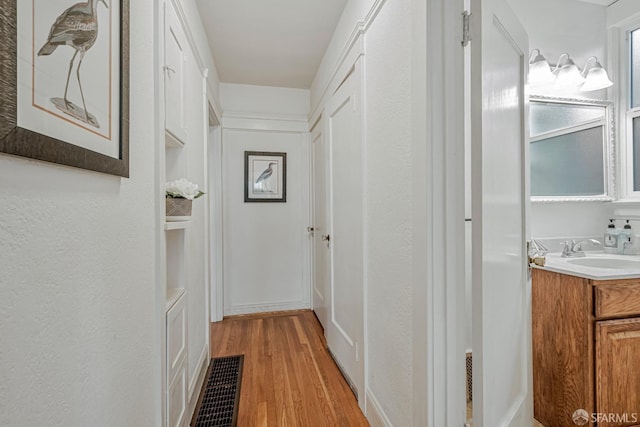 2375 31st Ave, San Francisco, CA 94116 - hallway with visible vents, a sink, and light wood finished floors