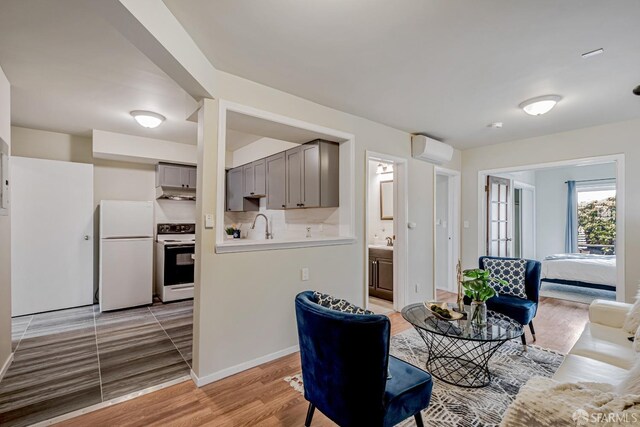 2375 31st Ave, San Francisco, CA 94116 - living room featuring baseboards, light wood-style flooring, and a wall mounted air conditioner