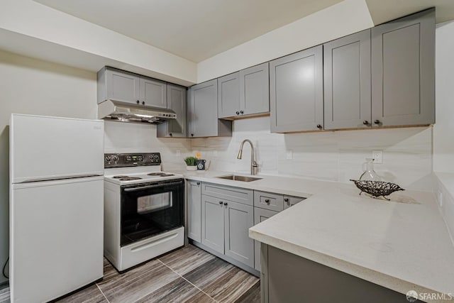 2375 31st Ave, San Francisco, CA 94116 - kitchen featuring freestanding refrigerator, range with electric stovetop, under cabinet range hood, a sink, and gray cabinetry