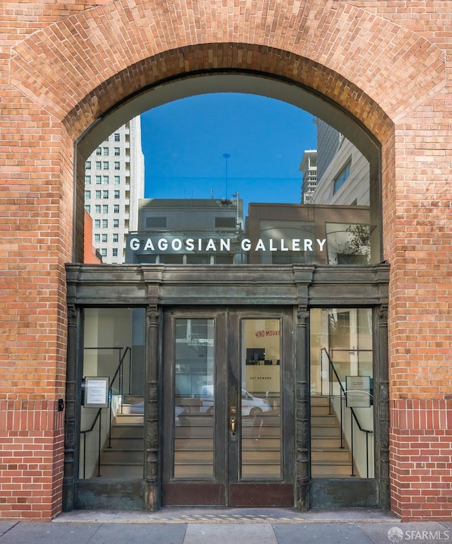 view of exterior entry featuring brick siding