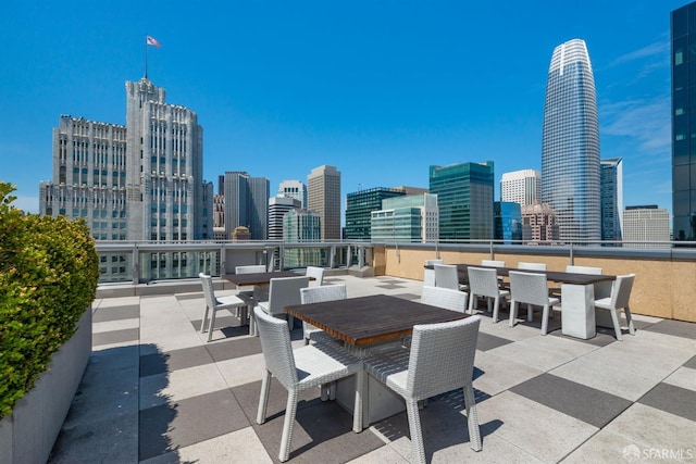 view of patio with outdoor dining space and a view of city