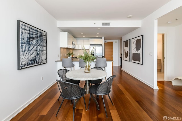 dining space featuring dark wood finished floors, recessed lighting, baseboards, and visible vents