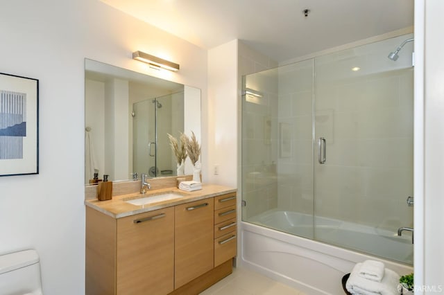 bathroom with vanity, toilet, and enclosed tub / shower combo